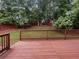 View from the deck of a backyard featuring a red fence and mature trees at 200 Eagle Glen Ct, Woodstock, GA 30189