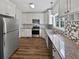 Well-lit kitchen features white cabinets, granite countertops, and stainless steel appliances at 200 Eagle Glen Ct, Woodstock, GA 30189