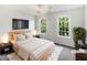 Cozy bedroom with a bed, TV, nightstands, and large windows offering bright, natural light at 200 Eagle Glen Ct, Woodstock, GA 30189