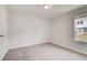Small carpeted bedroom with a window overlooking the backyard of the home at 212 Sanctuary Drive, Mcdonough, GA 30253