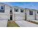 Exterior view of white brick townhomes with detailed landscaping and attached garages at 212 Sanctuary Drive, Mcdonough, GA 30253