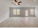 Bright and airy living room featuring hardwood floors, a ceiling fan, and ample windows at 212 Sanctuary Drive, Mcdonough, GA 30253