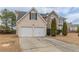 Two-story home with a two-car garage, stone accents, and well-kept landscaping at 325 Welsh Ct, Fairburn, GA 30213