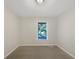Carpeted bedroom with a window and neutral walls at 5394 Muirwood Pl, Powder Springs, GA 30127