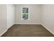 An empty bedroom with a window, closet, and carpet at 5394 Muirwood Pl, Powder Springs, GA 30127