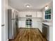 Bright kitchen featuring stainless steel appliances and white cabinets at 5394 Muirwood Pl, Powder Springs, GA 30127