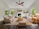 Staged living room featuring a fireplace, hardwood floors, and lots of natural light at 5394 Muirwood Pl, Powder Springs, GA 30127