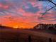 Stunning sunrise over a tranquil landscape with fields and trees at 4800 Pisgah Rd, Cumming, GA 30028