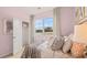 Stylish bedroom boasts a window overlooking green space, complemented by chic decorations and pink accent wall at 130 Oakchase Park Ln, Hampton, GA 30228