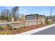 The Oakchase at Hampton neighborhood entrance features a brick wall and stone pillars with manicured landscaping at 130 Oakchase Park Ln, Hampton, GA 30228