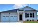 Charming, new construction home featuring a brick facade, a two-car garage, and a welcoming entryway at 130 Oakchase Park Ln, Hampton, GA 30228