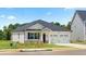 Charming home with white siding, black shutters, an attached two-car garage, and a well-manicured lawn at 130 Oakchase Park Ln, Hampton, GA 30228