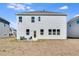 The home's backyard features a concrete patio with seating and an empty lot with sparse grass at 93 Sheryl Way, Loganville, GA 30052