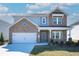 Charming two-story home featuring brick facade, a two-car garage, and a welcoming front porch at 93 Sheryl Way, Loganville, GA 30052