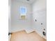 The laundry room features a window, wood flooring, and a wire shelf above the washer/dryer hookups at 93 Sheryl Way, Loganville, GA 30052