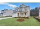 Two-story house with light brick exterior, a tree in the front yard, and a neatly landscaped lawn at 6098 Marigold Way, Atlanta, GA 30349