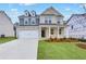 Two-story home with gray and beige exterior, white garage door, and landscaped yard at 6098 Marigold Way, Atlanta, GA 30349