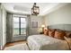 Bright bedroom with a large window, decorative light fixture, and comfortable bed with accent pillows at 88 W Paces Ferry Nw Rd # 1740, Atlanta, GA 30305