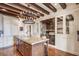 Elegant kitchen with wood beams, granite counters, an island, custom cabinets, and a wine storage area at 88 W Paces Ferry Nw Rd # 1740, Atlanta, GA 30305