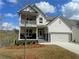 Charming two-story home with white siding, stone accents, a two-car garage and a cozy second-floor balcony at 151 Sunshower Rdg, Canton, GA 30114