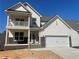 Charming two-story home with white siding, stone accents, a two-car garage and a cozy second-floor balcony at 151 Sunshower Rdg, Canton, GA 30114