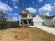 Charming two-story home with white siding, stone accents, a two-car garage and a cozy second-floor balcony at 151 Sunshower Rdg, Canton, GA 30114