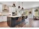 Modern kitchen with an island, pendant lighting, white cabinets, stainless steel appliances, and barstool seating at 151 Sunshower Rdg, Canton, GA 30114