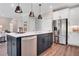 Contemporary kitchen island featuring a dishwasher, seating, and view of stainless steel refrigerator and living area at 151 Sunshower Rdg, Canton, GA 30114
