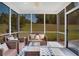 Relaxing screened porch with wicker seating, neutral pillows, an area rug, and outdoor views at 151 Sunshower Rdg, Canton, GA 30114