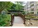 Wooden footbridge over a tranquil stream in a lush garden at 1850 Cotillion Dr # 3221, Dunwoody, GA 30338