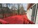 View of bright red wooden deck overlooking a wooded backyard at 1000 Melrose Park Pl, Lawrenceville, GA 30044