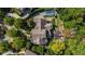 The aerial view reveals a luxurious home with a pool, outdoor kitchen, and manicured gardens, surrounded by lush trees at 980 Fenimore Cir, Sandy Springs, GA 30350