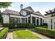 White brick home featuring manicured hedges, screened porch, and a stone walkway in a beautifully landscaped yard at 980 Fenimore Cir, Sandy Springs, GA 30350