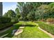 Backyard with manicured lawns, hedges and stepping stone pathway, offering a serene outdoor space at 980 Fenimore Cir, Sandy Springs, GA 30350