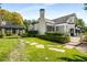 Expansive backyard with lush lawn, mature trees, stepping stone pathway, and charming pergola at 980 Fenimore Cir, Sandy Springs, GA 30350