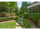 The backyard boasts lush landscaping with manicured hedges, stone pathways, and colorful flowering plants at 980 Fenimore Cir, Sandy Springs, GA 30350