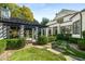 Stunning backyard with a pergola, manicured hedges, stone path, and elegant white exterior with black trim at 980 Fenimore Cir, Sandy Springs, GA 30350