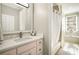 A bright bathroom featuring a marble vanity, shower with tub, and bright light fixture at 980 Fenimore Cir, Sandy Springs, GA 30350