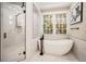 Elegant bathroom with a freestanding tub, glass-enclosed shower, and marble-look tile at 980 Fenimore Cir, Sandy Springs, GA 30350