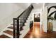 Stairway with dark wood steps and sleek black railings, showcasing modern decor, and hardwood flooring at 980 Fenimore Cir, Sandy Springs, GA 30350