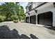 Spacious three-car garage featuring sleek black doors and a large driveway with a basketball hoop at 980 Fenimore Cir, Sandy Springs, GA 30350