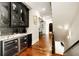 Hallway has hardwood floors with a modern bar featuring glass cabinets, wine fridges, and marble counters at 980 Fenimore Cir, Sandy Springs, GA 30350