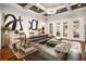 Bright living room featuring a coffered ceiling, modern chandelier, hardwood floors, and a large gray leather sectional sofa at 980 Fenimore Cir, Sandy Springs, GA 30350