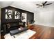 Stylish living area with dark accent wall, hardwood floors, a plush rug, and elegant furnishings, creating a chic and inviting space at 980 Fenimore Cir, Sandy Springs, GA 30350