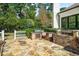 A beautiful outdoor kitchen and grill with stone pavers is framed by lush landscaping and a white picket fence at 980 Fenimore Cir, Sandy Springs, GA 30350