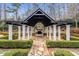 Outdoor pergola with stone fireplace, white pillars, and landscaped yard at 980 Fenimore Cir, Sandy Springs, GA 30350