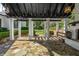 Elegant outdoor pergola with stone fireplace, white pillars, and manicured greenery at 980 Fenimore Cir, Sandy Springs, GA 30350