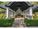 Outdoor space with an outdoor fireplace, covered seating, and lush landscaping at 980 Fenimore Cir, Sandy Springs, GA 30350