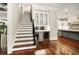 View of the staircase with a built-in bar with wine coolers, and a peek into the adjacent kitchen area at 980 Fenimore Cir, Sandy Springs, GA 30350