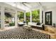 Relaxing sunroom featuring stone floors, comfortable seating, and backyard views at 980 Fenimore Cir, Sandy Springs, GA 30350